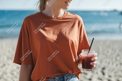 Orange shirt woman holding drink beach image Product Image 1