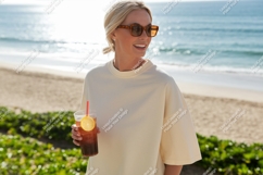 Woman holding iced drink on beach blonde sunglasses Product Image 1