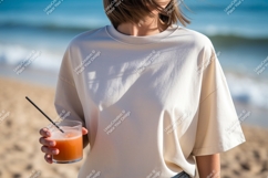 Woman holding orange drink on beach image Product Image 1