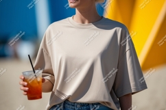 Beige t shirt holding orange drink image Product Image 1