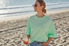 Woman wearing mint green t shirt holding drink image Product Image 1