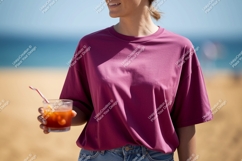 Woman in pink shirt holding drink at beach image Product Image 1