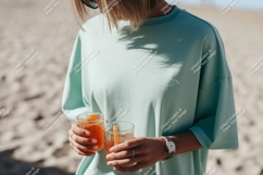 Mint shirt holding refreshing drinks on sand image Product Image 1