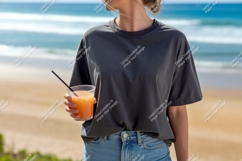 Woman holding orange drink on beach ocean sand Product Image 1