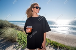 Woman holding drink on beach black t-shirt Product Image 1