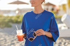 Woman holding drink sunglasses beach blue Product Image 1