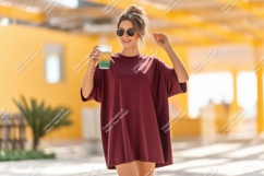Woman holding drink wearing oversized maroon t shirt Product Image 1