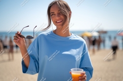 Blue shirt woman holding sunglasses and drink image Product Image 1