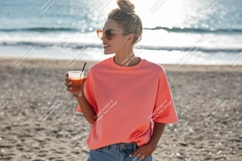 Woman holding drink on beach sand ocean Product Image 1