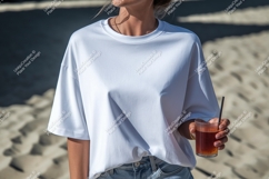 Woman wearing white t shirt holding drink on beach Product Image 1