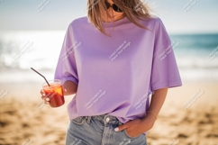 Woman wearing purple t shirt holding drink on beach Product Image 1