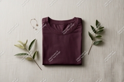 Folded maroon t shirt with jewelry and leaves image Product Image 1