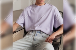 Man Wearing Lilac Tshirt Mockup On Chair Product Image 1