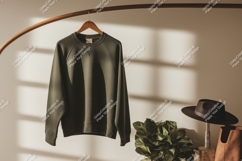 Olive green sweatshirt hanging on rack clothing apparel Product Image 1
