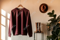 Maroon sweatshirt hanging with hat boots and plants Product Image 1
