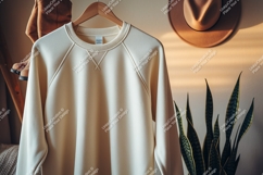 Creamy sweatshirt hanging on a wooden hanger clothing Product Image 1