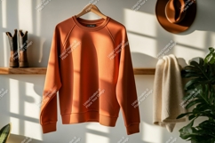 Orange sweatshirt hanging indoors clothing apparel Product Image 1
