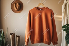 Orange sweatshirt hanging on hanger clothing apparel Product Image 1