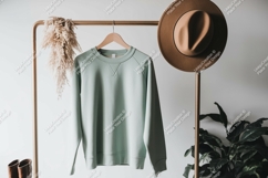 Mint green sweatshirt hanging on rack with hat clothing Product Image 1