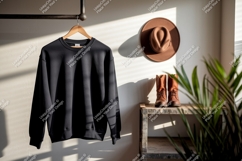 Black sweatshirt hanging on rack with hat and boots Product Image 1