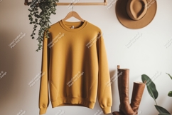 Mustard yellow sweatshirt hanging with boots and hat Product Image 1