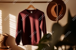 Maroon sweatshirt hanging on rack with hat and boots Product Image 1