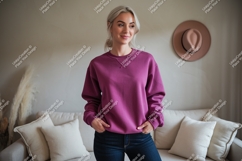 Woman wearing magenta sweatshirt jeans couch Product Image 1