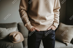 Man wearing beige sweatshirt and dark jeans Product Image 1