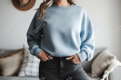 Woman wearing light blue sweatshirt and dark jeans Product Image 1