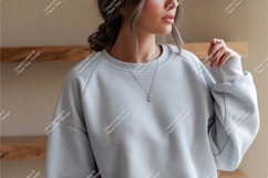 Format: Title: Woman wearing grey sweatshirt with necklace Product Image 1