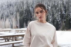 Woman wearing cream sweatshirt in snowy forest image Product Image 1
