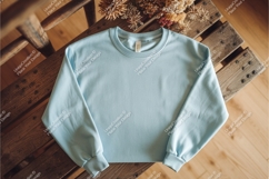 Blue sweatshirt on wooden surface mockup Product Image 1