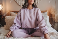Woman in lilac sweatshirt on bed mockup Product Image 1