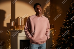 Man wearing pink sweatshirt with gifts and Christmas tree Product Image 1
