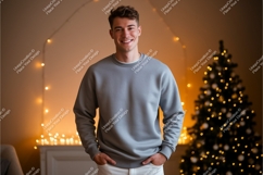 Young man wearing grey sweatshirt near christmas tree Product Image 1