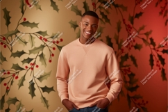 Man wearing peach sweatshirt with holly background Product Image 1