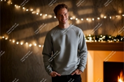 Young man wearing grey sweatshirt by fireplace lights Product Image 1