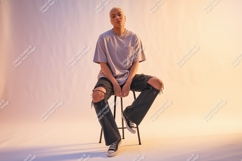 Person wearing ripped jeans and t shirt sitting stool Product Image 1