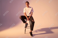 Young man white t shirt ripped jeans sitting stool Product Image 1
