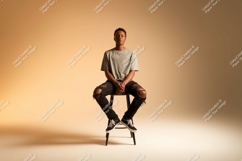 Young man seated on stool grey t-shirt Product Image 1
