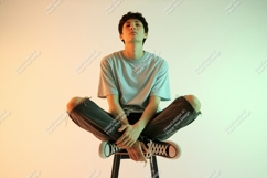 Young man sitting cross-legged on stool Product Image 1