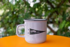 mockup-of-a-12-oz-enamel-coffee-mug-placed-in-an-outdoor-setting-with retro pennant design