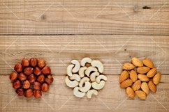 Hazelnuts, almonds and cashew nuts on wooden background Product Image 1