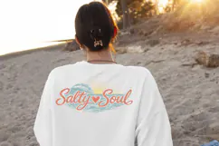 Coastal sublimation design with textured ocean waves and sunset rays behind the phrase “Salty Soul” in beach inspired colors.