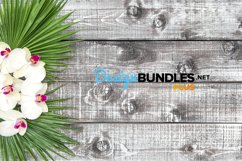 Orchid flowers palm leaves floral decoration on wooden background