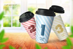 	 Paper coffee cup mockup of three cups on wooden tabletop with bright window background