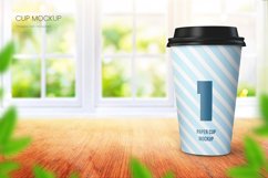 Realistic paper coffee cup mockup in bright room with big window
