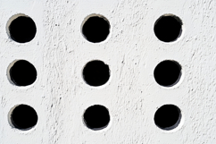 White Wall with Black Holes Background Wallpaper Product Image 1