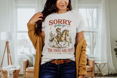 Sarcastic western themed shirt graphic featuring a cartoon cowboy cat on horseback with distressed western typography and desert cactus elements for a humorous cowgirl style design.
