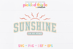 “Sunshine On My Mind” design with bold varsity lettering, soft teal and coral tones, and simple sun rays above, slightly distressed texture on a white background